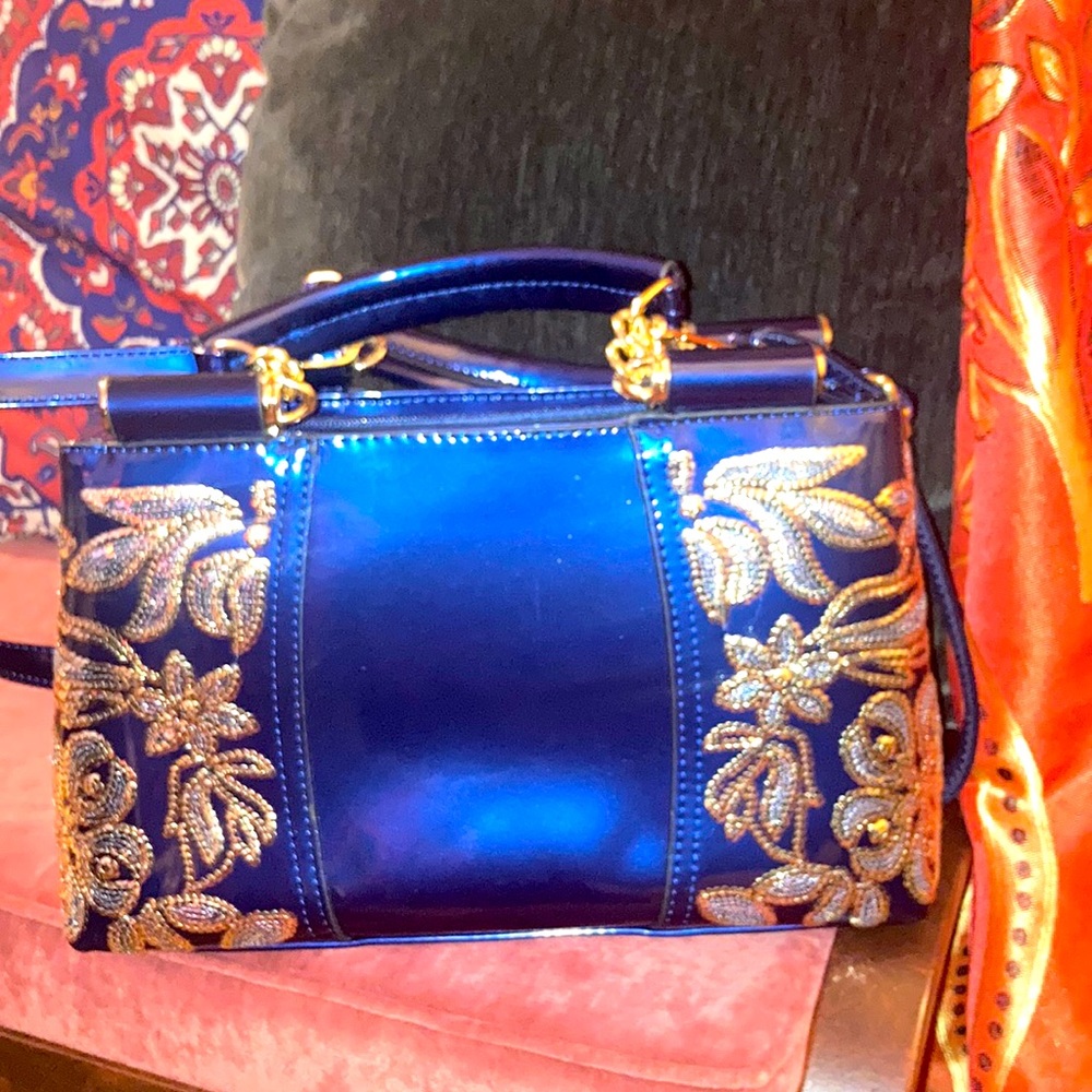 Blueberry vegan patent leather purse with silver and gold embellishment.